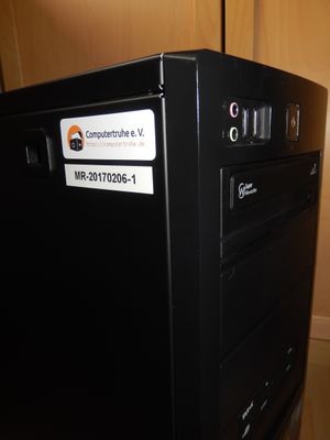 Auf einem Desktop-PC befinden sich auf einem Seitenteil ein Aufkleber mit dem Vereinslogo und der Schriftzug „Computertruhe e. V. https://computertruhe.de“ und ein Aufkleber mit der Seriennummer „MR-20170206-1“.